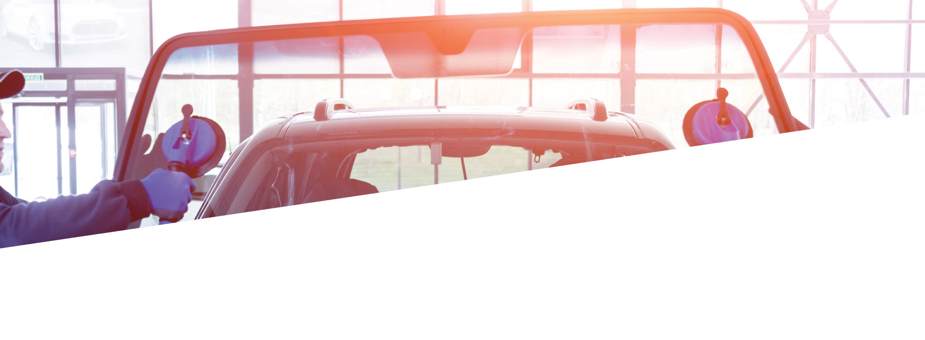 Auto glass technician fitting new glass inside a vehicle